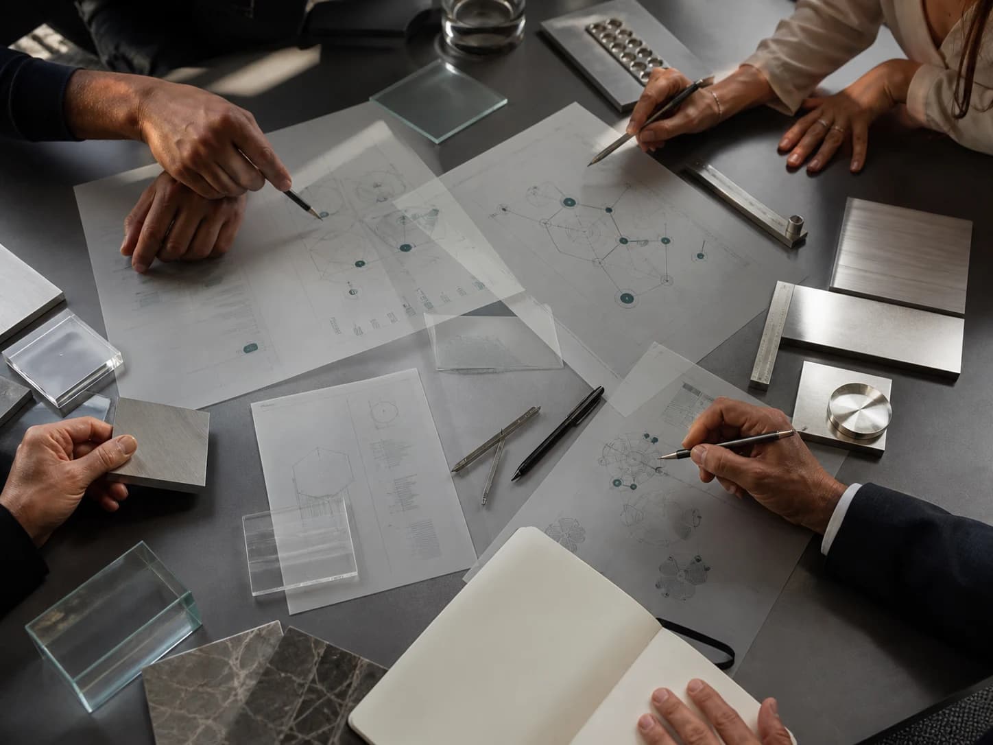Equipe multidisciplinar colaborando sobre materiais científicos e estratégicos